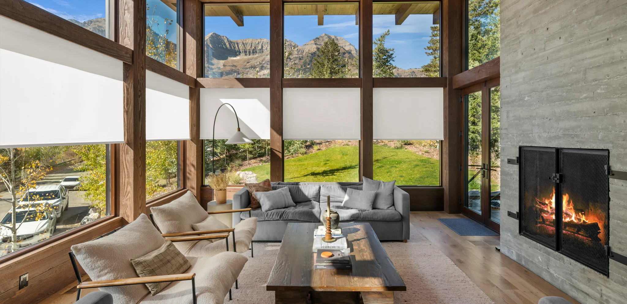 White roller shades in a large sunroom with a mountain scenery