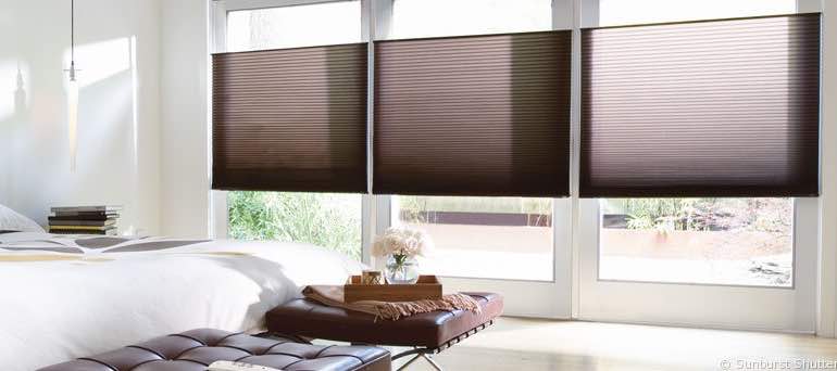 Minimal Denver bedroom with high windows and brown cellular shades.