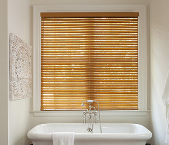 light faux wood blinds above a modern bathtub