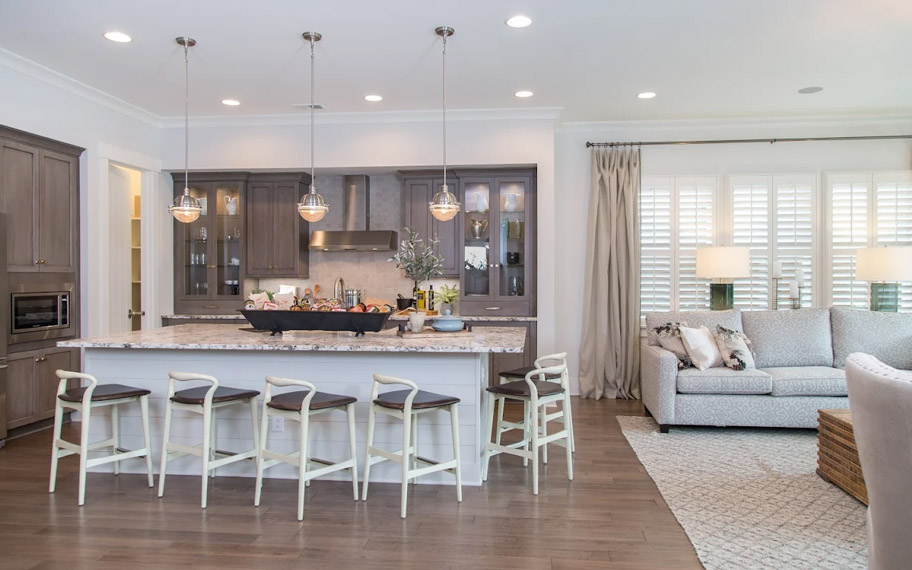 Illuminate your home with custom interior shutters in Denver. White arched shutters in a white kitchen with lots of light.