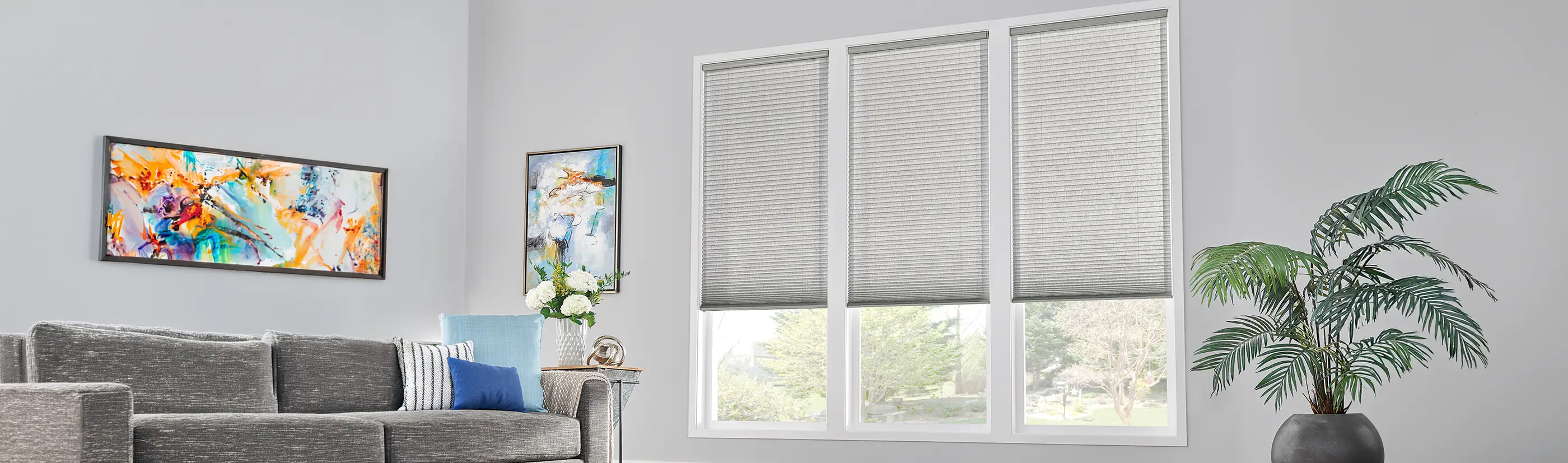 Gray cell shades in three large windows inside of a living room