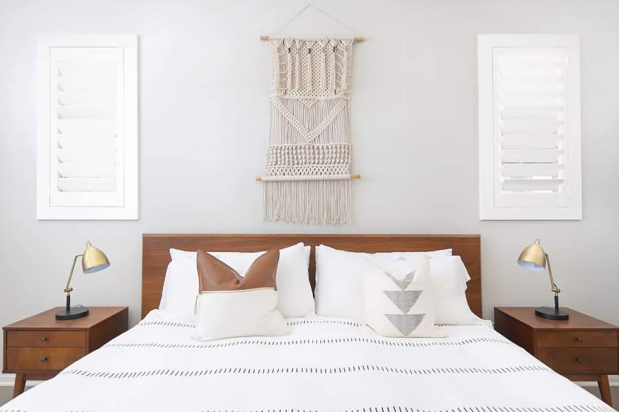 Use an outside-mounted frame to add stylish trim around your windows. Outside-mount Polywood shutters on two bedroom windows