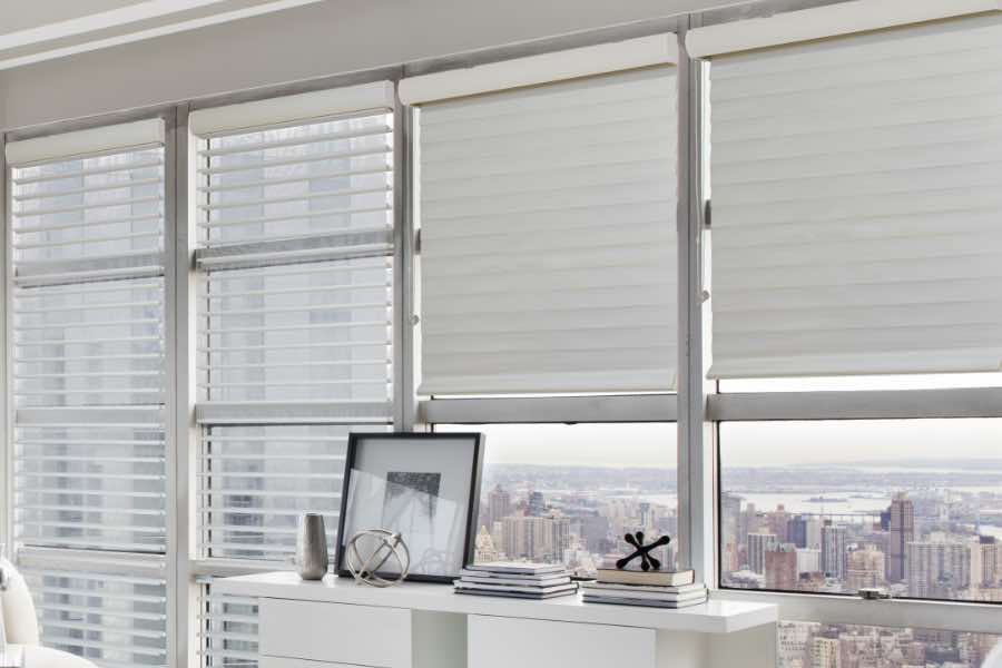 If you like the look of sheer window treatments but still need to block light and have some privacy, go with sheer window shades. White sheer window shades on windows in a high rise penthouse bedroom