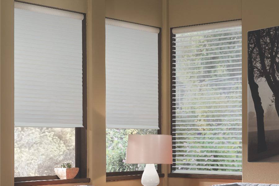 Opaque motorized window shades in Denver keep hot UV rays out of your home. Gray motorized sheer shades on corner windows next to gray furniture