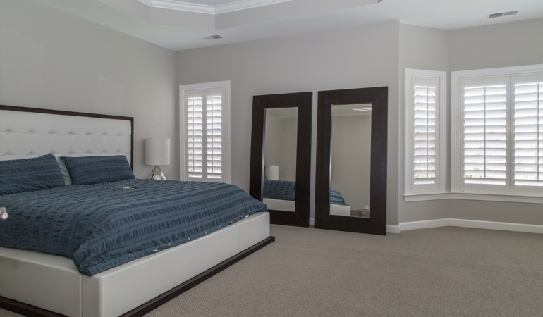 Polywood plantation shutters combine form and function. Polywood shutters in a minimalist bedroom in Denver.