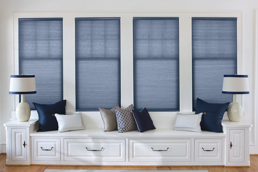 Keep the Denver cold at bay with insulating and stylish cellular window shades. Blue cellular shades on windows by a window seat