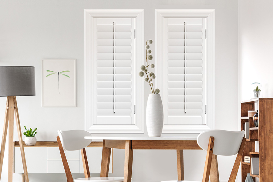 Sunburst's selection of stylish window treatments for designers in Denver makes it easy to find the perfect ones for every design job.  White Polywood shutters on two windows in a modern Scandinavian-style room
