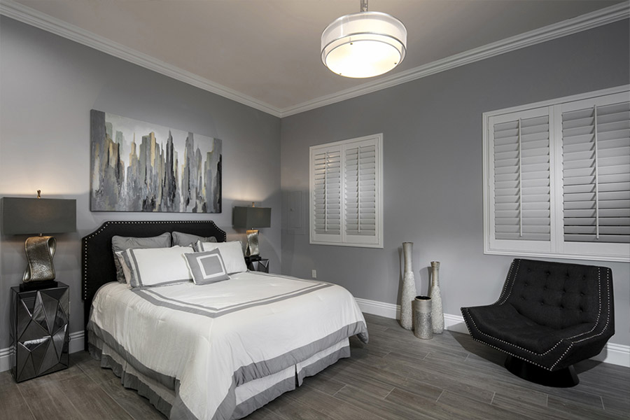 Create the perfect sleeping space with Polywood shutters that block even the brightest light.  Closed white Polywood shutters on windows in a gray bedroom