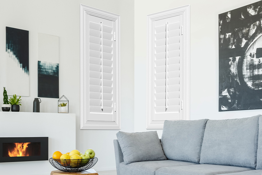 White Polywood shutters add character and class in Denver. White polywood shutters in a corner of a modern living room.