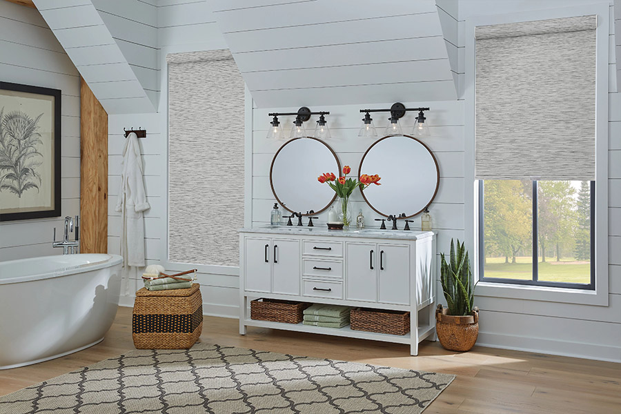 Slim-profile roller shades easily fit shallow windows in your Denver home. Gray patterned roller shades on bathroom windows