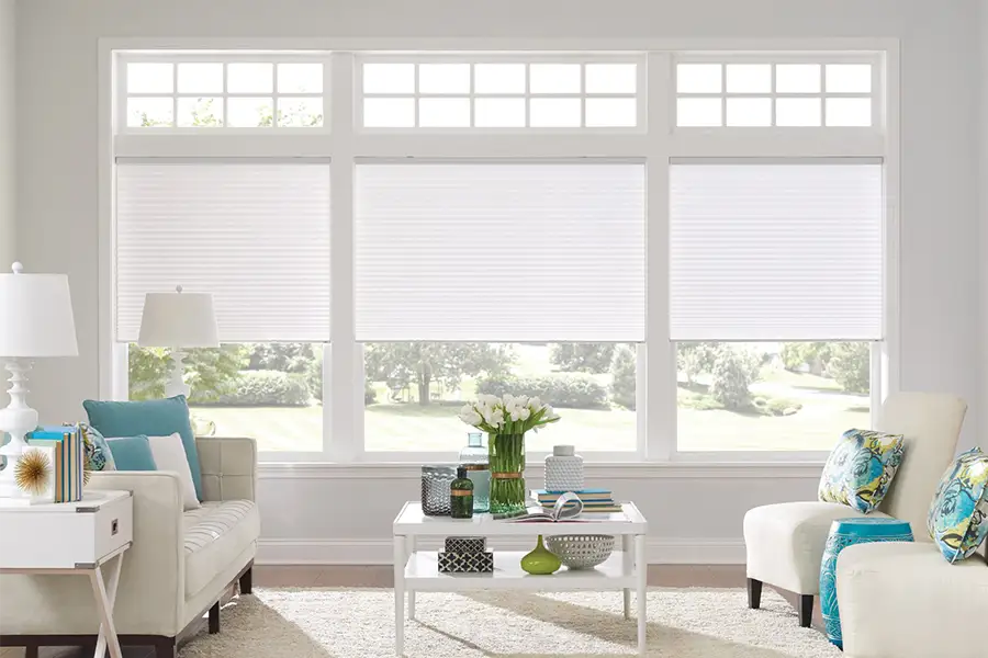 Insulating cellular shades can help keep cold air and hot UV rays from entering your Denver home. White cellular shades on windows in a white living room